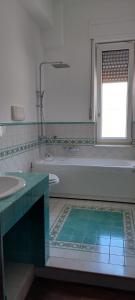 un bagno con vasca, lavandino e finestra di Giulia Town House tra città e mare a Salerno Altre 33 foto