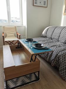 a living room with a coffee table and a bed at Appartement "La Marine" vue mer in Saint-Pair-sur-Mer