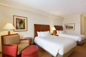 um quarto de hotel com duas camas e uma cadeira em Hilton Garden Inn Shreveport em Shreveport