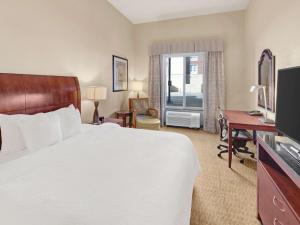 Habitación de hotel con cama, escritorio y TV. en Hilton Garden Inn Oklahoma City North Quail Springs en Oklahoma City