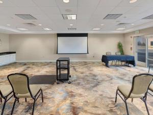 a meeting room with a table and chairs and a screen at Hilton Garden Inn Oklahoma City North Quail Springs in Oklahoma City