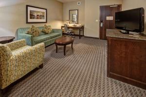 a hotel room with couches and a flat screen tv at Hilton Garden Inn Midtown Tulsa in Tulsa