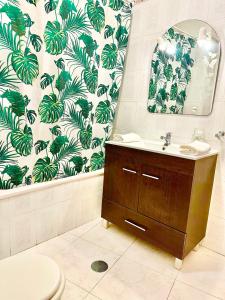 a bathroom with a toilet and a sink and a mirror at Rei Apartment in Quarteira