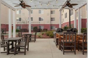 un patio con tavoli e sedie e un edificio di Homewood Suites by Hilton Tallahassee a Tallahassee