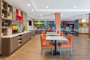 una cafetería con mesa y sillas y una cocina en Home2 Suites By Hilton Redlands en Redlands