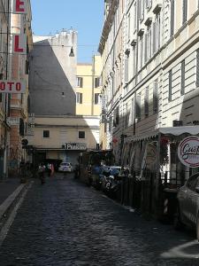 una strada di ciottoli in una città con edifici di Signorina In Rome a Roma