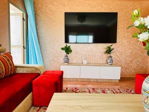 ein Wohnzimmer mit einem roten Sofa und einem Fernseher in der Unterkunft Oualidia29 in Oualidia