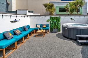Un patio con sofás azules y un jacuzzi. en Finest Retreats - Lobster House, en Newquay