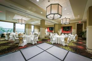 un salón de banquetes con mesas y sillas blancas en Hilton Garden Inn Rochester Downtown, NY en Rochester