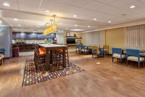 a waiting room with chairs and a table and a bar at Hampton Inn Waterbury in Waterbury