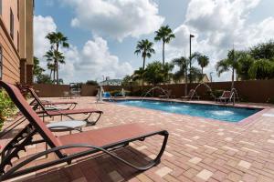 a swimming pool with two chairs and a swimming pool at Hampton Inn & Suites Pharr in Pharr