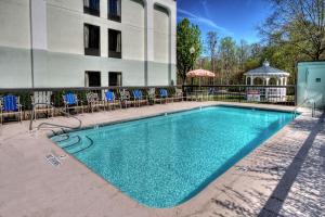 a swimming pool in front of a building with chairs and a gazebo at Hampton Inn Jonesville/Elkin in Arlington