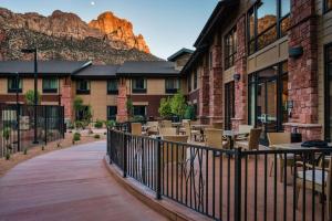 a patio with tables and chairs in front of a building at Hampton Inn & Suites Springdale/Zion National Park in Springdale