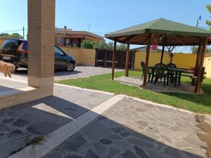 een patio met een tafel en een prieel bij Cottage OstiaAntica in Ostia Antica
