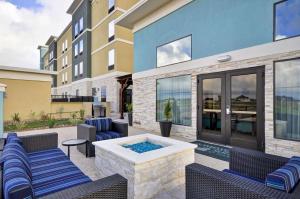 a patio with chairs and a hot tub in front of a building at Homewood Suites by Hilton New Braunfels in New Braunfels