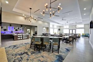 a dining room with tables and chairs and a kitchen at Homewood Suites by Hilton New Braunfels in New Braunfels