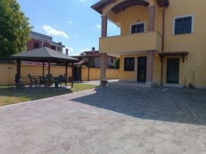 a house with a patio and a table and umbrella at Cottage OstiaAntica in Ostia Antica