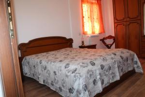 a bedroom with a bed with a comforter on it at Cottage OstiaAntica in Ostia Antica