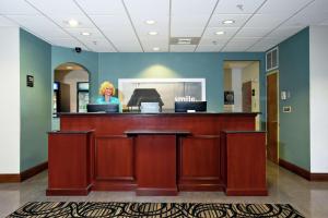 Hampton Inn & Suites - Fort Pierce في فورت بييرس: امرأة تقف في صندوق النقد لمكتب الأسنان