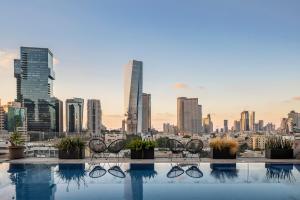 a rooftop pool with a view of a city at Jo Shtibel Tel-Aviv in Tel Aviv