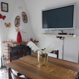 uma sala de jantar com uma mesa e uma televisão na parede em Nicola's house em Campo di Giove