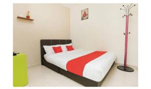 1 dormitorio con 1 cama con manta roja y blanca en Semerah Suites Homestay, en Pontian Kecil