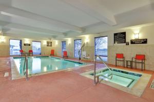 una gran piscina en un hotel con sillas rojas en Hampton Inn & Suites Fort Worth/Forest Hill en Forest Hill