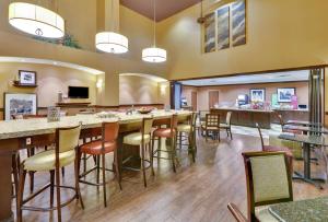 a large room with a bar with stools at Hampton Inn & Suites Fort Worth/Forest Hill in Forest Hill