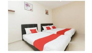 1 dormitorio con 2 camas con sábanas rojas y blancas en Semerah Suites Homestay, en Pontian Kecil