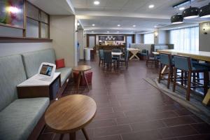a restaurant with tables and chairs and a bar at Hampton Inn Fayetteville in Fayetteville