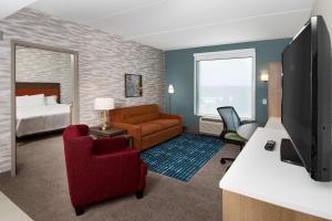 a hotel room with a bed and a living room at Home2 Suites By Hilton Roswell, Ga in Roswell