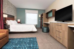a bedroom with a bed and a flat screen tv at Home2 Suites By Hilton Roswell, Ga in Roswell