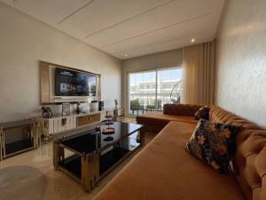 a living room with a couch and a tv at Appartement de luxe à peninsula in Casablanca