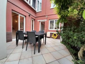 a black table and chairs on a patio at La Glycine in Mers-les-Bains