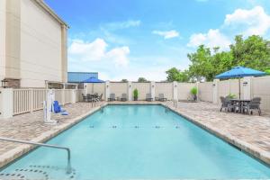 una piscina con mesa, sillas y sombrilla en Hampton Inn Thomasville, en Thomasville