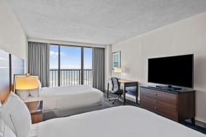 ein Hotelzimmer mit 2 Betten und einem Flachbild-TV in der Unterkunft DoubleTree by Hilton Atlantic Beach Oceanfront in Atlantic Beach