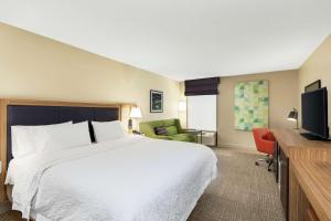 a hotel room with a bed and a flat screen tv at Hampton Inn Thomasville in Thomasville