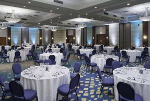une salle de banquet avec des tables blanches et des chaises bleues dans l'établissement DoubleTree by Hilton Atlantic Beach Oceanfront, à Atlantic Beach