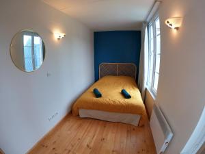 Dormitorio pequeño con cama y espejo en La Glycine en Mers-les-Bains