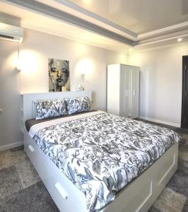 - une chambre avec un grand lit et une couette noire et blanche dans l'établissement Guest House in Mykolaiv, à Mykolaïv