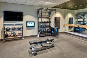 a fitness room with a gym with a bench and weights at Tru By Hilton Roanoke Hollins in Roanoke