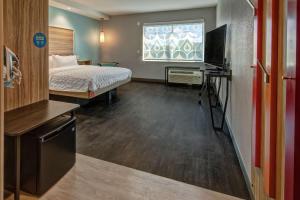 a hotel room with a bed and a television at Tru By Hilton Roanoke Hollins in Roanoke