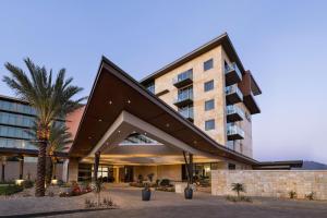 a building with a palm tree in front of it at Hilton North Scottsdale At Cavasson in Scottsdale