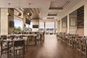 Hilton North Scottsdale At Cavasson في سكوتسديل: مطعم فيه طاولات وكراسي في الغرفة