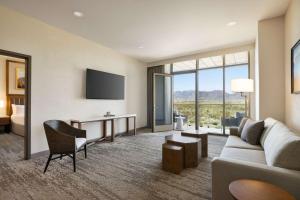 Habitación de hotel con sofá, escritorio y cama en Hilton North Scottsdale At Cavasson en Scottsdale