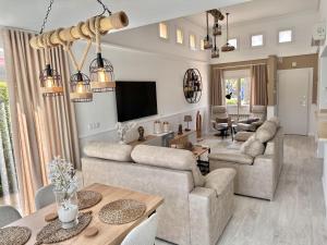 ein Wohnzimmer mit zwei Sofas und einem Fernseher in der Unterkunft Luxurious Frontline Golf Villa on Mar Menor Golf in Torre-Pacheco