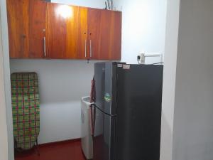 a kitchen with a black refrigerator and wooden cabinets at Colombo Home Stay - Horahena in Kaduwela +5 photos