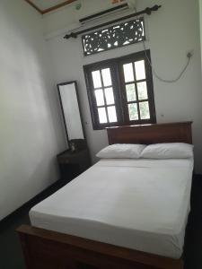 a bedroom with a white bed and a window at Colombo Home Stay - Horahena in Kaduwela