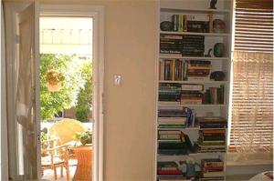a book shelf filled with books in a living room at Australis Guest House in Ottawa