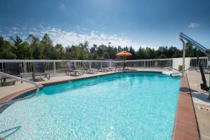 a large swimming pool with chairs and an umbrella at Hampton Inn Cornelia in Cornelia